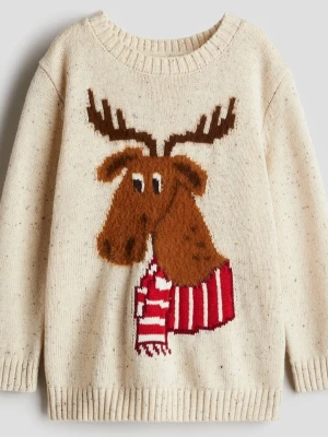 Beige stickad tröja med älg från H&M - Säljer en beige stickad tröja från H&M med ett stort motiv av en brun älg med fluffig päls och horn framtill. Älgen har en röd och vit randig halsduk. Tröjan har rund hals och långa ärmar, perfekt för vintern och julen.