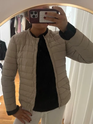 Beige pufferjacka från H&M - Säljer en beige pufferjacka från H&M i storlek 38. Jackan har en stilren, quiltad design med rund krage och knäppning framtill. Perfekt för dig som vill ha en lätt och smidig jacka till vardags. Passar snyggt till både jeans och mjukisbyxor.