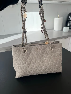 Guess väska  - Otroligt fin Guess väska med fina detaljer på kedjan. Nästan i nyskick 