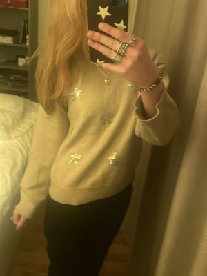 Beige stickad tröja med silverstjärnor💕 - Säljer en beige stickad tröja med glittriga silverstjärnor🫰🏼jättegullig och passar vid alla tillfällen💗💗