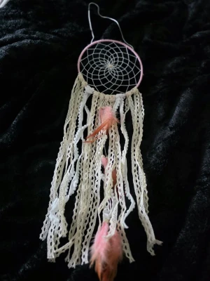 Drömfångare med spets och fjädrar - Unik drömfångare med rosa ring, vitt nät och långa spetsband i beige. Dekorerad med rosa och vita fjädrar samt olika band för en bohemisk känsla. Perfekt som dekoration i sovrummet eller på väggen.