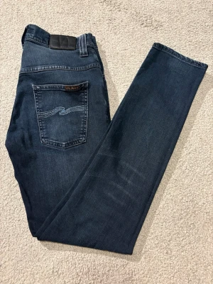 Nudie Jeans - Asfeta mörkblåa jeans i modellen Thin Finn🙌 Storlek📐:W29 L32. Jeansen är i väldigt bra skick! Mått finns att få! Hör gärna av dig intresse eller frågor🤝