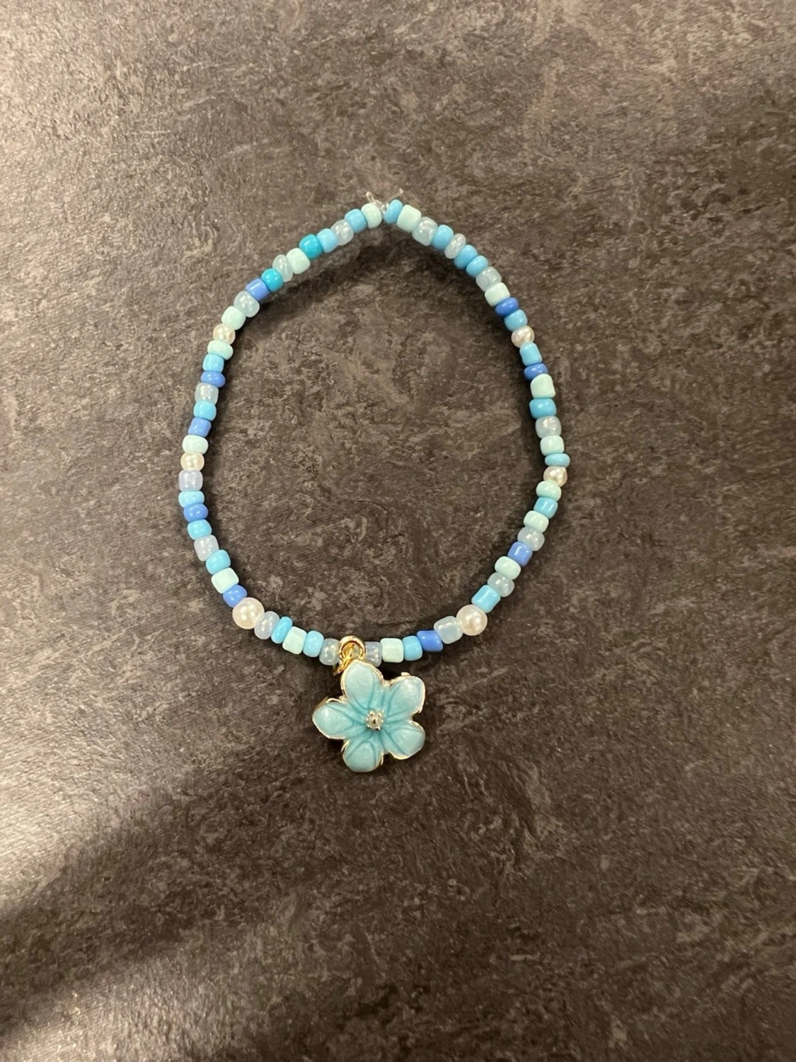 Blått pärlarmband med blomberlock Storlek M