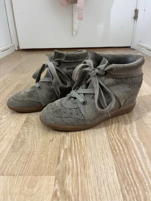 Isabel Marant Skor - Jag säljer ett par jätte snygga ocj trendiga Isabel Marant skor. Skorna är köpta på plick, men har bara använts fåtal gånger. Som bild nummer 6 visar så har den några slitningar där bak på vänster sko, men annars är de som nya!