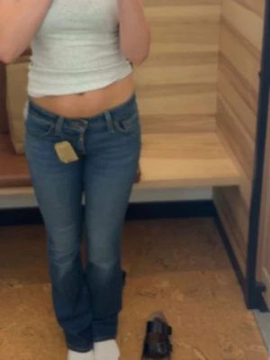 Levi's blå raka jeans - Säljer ett par klassiska blå Levi's jeans med raka ben och normal midja. Jeansen har fem fickor, snygga kontrastsömmar och den ikoniska läderlappen bak i midjan. Perfekta till vardagslooken och passar till det mesta.