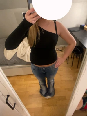Svart one shoulder topp - Säljer en svart one shoulder topp med lång ärm på ena sidan. Snygg och tight passform som framhäver figuren. Perfekt för fest🎉 