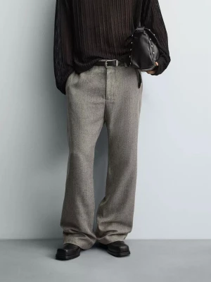 Utsvängda grå kostymbyxor i ullblandning - Stilrena grå kostymbyxor med utsvängd passform och pressveck. Byxorna har bälteshällor och stängs med dragkedja och knapp. Perfekta för en dressad look och tillverkade i en mjuk ullblandning. (Storlek 38 men passar som 30)