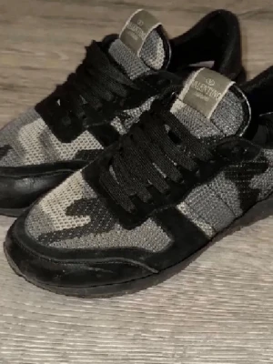 Valentino rockrunners - Snygga Valentino Rockrunner sneakers i svart och grått camouflagemönster. Ovandel i mesh och mocka med svarta snören och detaljer. Perfekta för dig som vill ha en unik och trendig look.