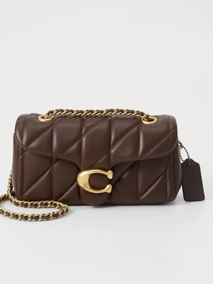 Brun quiltad axelväska från Coach - Snygg brun axelväska från Coach i quiltat läder med guldfärgad kedjerem och stor C-detalj framtill. Väskan har en kompakt rektangulär form och en elegant finish. Perfekt för dig som vill ha en trendig och stilren accessoar med exklusiv känsla.