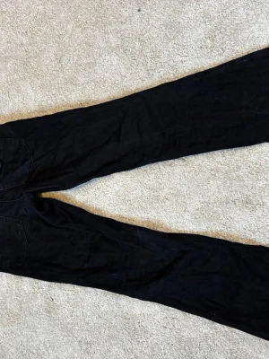 Svarta raka jeans - Svarta jeans med rak passform och klassiska bakfickor. Perfekta för dig som gillar en stilren look. Materialet ser ut att vara bomullsdenim.