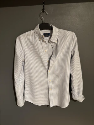 Randig skjorta från Polo Ralph Lauren - Klassisk skjorta från Polo Ralph Lauren i vitt och ljusblått. Den är i storlek S. Skick 9/10 inga defekter, nypris ligger på runt 1500. 