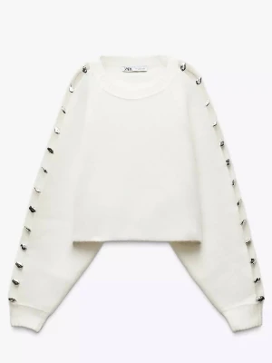 Vit stickad tröja med silverknappar Zara - Vit stickad tröja från Zara med rund halsringning och dekorativa silverfärgade knappar längs hela ärmarna. Tröjan har en rak, något boxig passform och ribbstickade muddar vid ärmslut och hals. Perfekt för dig som gillar unika detaljer. Denna är så fin och det är smärtsamt att sälja den! Köpt från Zara, helt nyskick🤍