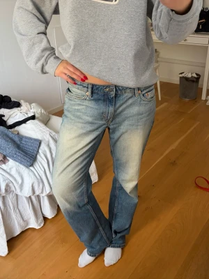 Blå raka jeans med vintage tvätt - Säljer ett par blå jeans med rak passform och snygg vintage tvätt. Jeansen har klassiska fem fickor, låg midja och slitna detaljer framtill och baktill. Perfekta för en avslappnad och trendig look.