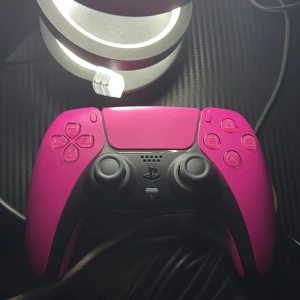 PlayStation 5 DualSense Wireless Controller - Cosmic Red - Snygg och välbevarad PlayStation 5 DualSense-kontroll i Cosmic Red. Alla knappar och spakar ser ut att vara i mycket gott skick, utan synligt slitage eller repor. Perfekt för dig som vill ha en extra kontroll till din PS5 eller spela med vänner.