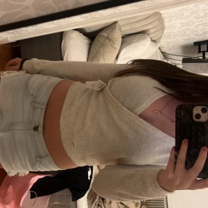 Beige omlottkofta från Kappahl - Supermysig beige omlottkofta från Kappahl med croppad passform och lång ärm. Koftan har en djup v-ringning, ribbade kanter och knyt i sidan. Perfekt för lager-på-lager och chill outfits.