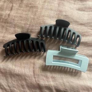 Tre hårklämmor i svart, smutsblått och ljusblått - Säljer tre stora hårklämmor i olika färger: en svart, en smutsblå och en ljusblå. Kom privat om du endast vill ha 1 eller 2 av dem. 