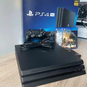 PlayStation 4 Pro 1TB + Assassin's Creed Origins & Odyssey + Samsung 870 EVO SSD - PlayStation 4 Pro 1TB i mycket fint skick, komplett med original DualShock 4-kontroll, kablar, två populära Assassin's Creed-spel och en ny Samsung 870 EVO 1TB SSD för extra lagring. Perfekt för gaming i 4K HDR. Inga synliga defekter eller slitage.