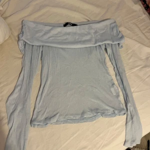 Ljusblå offshoulder topp från Bik Bok - Supersöt ljusblå offshoulder topp från Bik Bok med långa ärmar. Tunn och mjuk i materialet, perfekt för dig som gillar en enkel men trendig look. Sitter snyggt över axlarna och passar till både jeans och kjol.