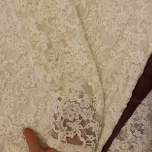 Vit spetsklänning från Amisu - Superfin vit tröja  från Amisu med långärmade ärmar och helblommig spets över hela plagget. Tröjan  har rund halsringning och är fodrad undertill, vilket ger en snygg kontrast till den genombrutna spetsen. Perfekt för dig som gillar romantisk och feminin stil.