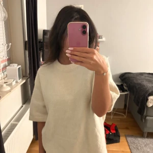 Vit stickad tröja från Gina Tricot - Supermjuk och stilren vit stickad tröja från Gina Tricot med korta ärmar och rund hals. Säljer för kommer ej till användning längre.
