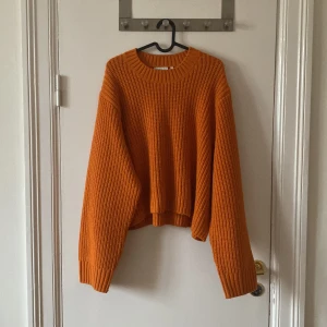 Orange stickad tröja från Weekday - Säljer en chunky orange stickad tröja från Weekday i storlek L. Tröjan har oversized passform, breda ärmar och grov ribbstickning. Något kortare modell.