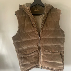 Brun dunväst från Stenströms - Snygg brun dunväst från Stenströms i manchester med huva och två stora fickor framtill. Västen har quiltad design, dragkedja och en cool retrovibe. Perfekt för lager-på-lager och chill höst- eller vinterstil. I nyskick! Tveka inte på att höra av dig vid frågor💓💓