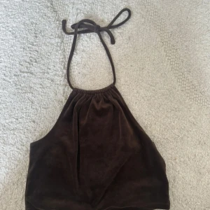 Brun sammets halterneck topp BikBok - Denna top är från BIKBOK och den är en del av ett sett med tillkommande byxor som jag dessvärre inte säljer. Den har snörning runt halsen och är såååå skön!!  Jag finns tillgänglig i Skövde, Borås & Värnamo om ni vill mötas istället för att betala frakt🙈❤️🥰