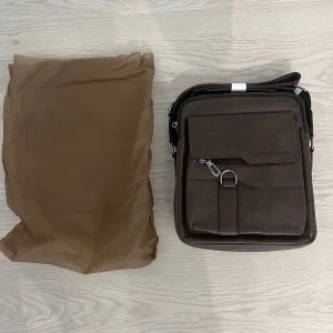 Brun axelväska från Calvin Klein - Axelremsväska köpt i turkiet. Perfekt väska för den som har mycket accessoarer med sig ut.