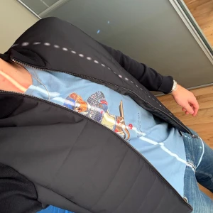 Svart pufferjacka från Massimo Dutti - Snygg svart pufferjacka från Massimo Dutti med stickade ärmar och quiltad front. Jackan har dragkedja hela vägen och en stilren, modern look. Perfekt för dig som vill ha en jacka som är både bekväm och trendig.