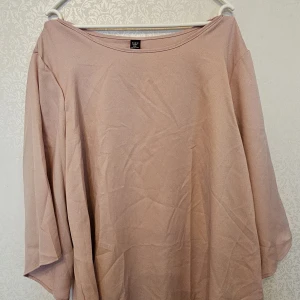 Beige blus från SHEIN Curve 2XL - En enkel och stilren beige blus från SHEIN Curve i storlek 2XL. Blusen har en lös passform med trekvartsärmar och rund halsringning. Perfekt för dig som gillar en avslappnad och clean look.