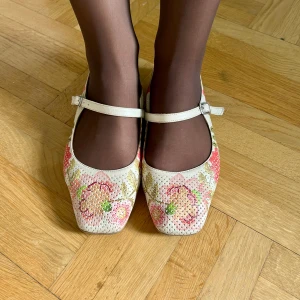 Blommiga ballerinaskor från Venezia - Söta ballerinaskor i vitt med broderade blommor i rosa, grönt och beige. Skorna har fyrkantig tå, tunn rem över foten med spänne och perforerat material. Är storlek 37, men jag har storlek 38 och dem sitter även lite för stort! Så dem passar perfekt för storlekarna mellan 37-38.5. Vit bakgrund och färgglada blommor runt omkring. Och en liten klack. Köpta i Warszawa💗