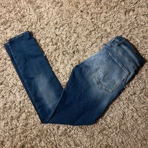 Replay anbass slim fit jeans - Snygga blå jeans från Replay med klassisk femficksdesign och ljusa slitningar. Jeansen har slim passform, normal midja och är tillverkade i mjukt denimtyg med stretch. Perfekta för dig som gillar en stilren och modern look.