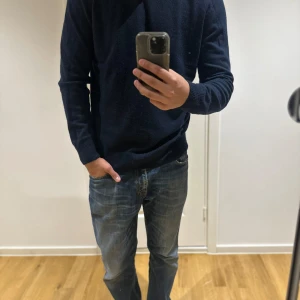 Mörkblå kashmir tröja herr 100% - En stilren mörkblå stickad tröja med rund hals och långa ärmar. Tröjan har en klassisk passform och ribbade muddar vid ärmslut och nederkant. Perfekt för dig som gillar en enkel och snygg look från massimodutti och stilren 100 kashe.