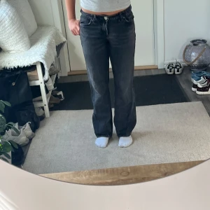 Svarta raka jeans från Zara - Säljer ett par svarta jeans från Zara med rak passform och klassisk femficksdesign. Jeansen har låg midja och är tillverkade i ett slitstarkt denimtyg. Perfekta för dig som gillar en tidlös och avslappnad stil.