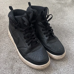 Nike höstskor svarta - Svarta clean Nike skor perfekt för hösten. Snyggt kontrasterande vit sula med grovt mönster för extra grepp. Skorna har en rund tå och är tillverkade i skinn och textil, med vadderad krage för skön komfort. Stl 45