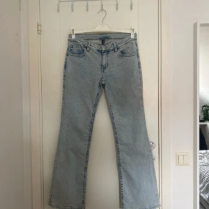 Ljusblå bootcut jeans från H&M Divided - Säljer ett par ljusblå bootcut jeans från H&M Divided i storlek 42. Jeansen har klassisk femficksdesign, broderade detaljer på bakfickorna och är tillverkade i bomull. Perfekt för dig som gillar en retro vibe och vill ha ett par snygga jeans med utsvängda ben. 🩵