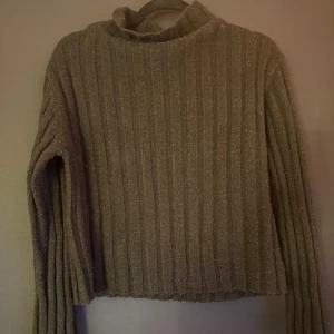 Svart ribbad polotröja Gina Tricot - Svart ribbstickad polotröja från Gina Tricot i storlek S. Tröjan har lång ärm och hög krage, perfekt för kyliga dagar. Den är stickad och har en klassisk, enkel look som funkar till allt.