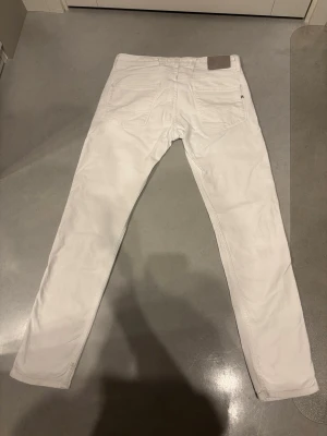 Vita Replay Anbass jeans - Säljer ett par vita Replay Anbass jeans, strl 31/32. Jeansen har slim passform och raka ben, perfekt för dig som vill ha ett par cleana vita jeans, prima till våren och sommaren! De är knappt använda heller, i princip nyskick. Säljer eftersom de var lite för små för mig.