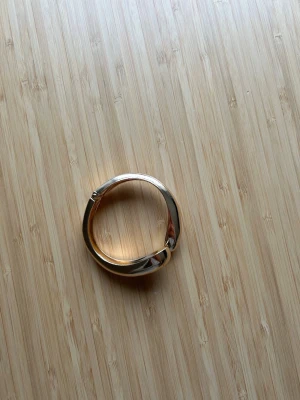  Guldfärgat armband - Snyggt guldfärgat armband i modern, elegant form. Enkelt att ta på och av. Passar både till vardag och fest