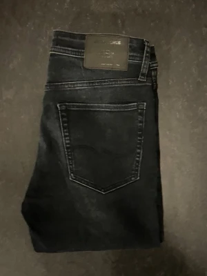 Jack&Jones jeans - Säljer ett par svarta jack&jones jeans snygg tvätt, storlek 30/32, slim fit. Mycket bekväma jeans och är stretchiga. Mycket fint skick där de har använts fåtal gånger.                                   Nypris 600kr                                                                           Mått: A=39cm B=79cm C=104cm D=15cm                      Fråga gärna om fler bilder eller om det är något ni generellt undrar!                                                Checka in profilen för liknande jeans!