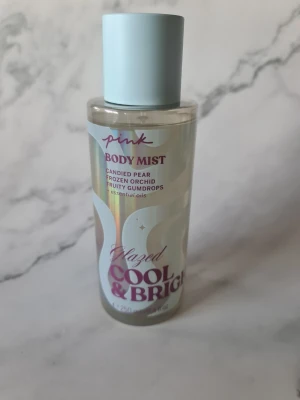 Glazed Cool & Bright Body Mist - Söt body mist med toner av sockrad päron, frusen orkidé och fruktiga gumdrops. Innehåller eteriska oljor. Volym: 250 ml. Vegansk, dermatologiskt testad och fri från artificiella färgämnen. Förpackning delvis av återvunnet material. Helt nytt och oanvänt