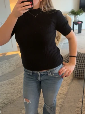 Svart ribbad topp med kort ärm - Säljer en svart ribbad topp med korta ärmar och rund hals. Toppen har en slim passform och är tillverkad i ett mjukt, stretchigt material. Den är från object och är endast använd 1-2 ggr så väldigt bra skick. 