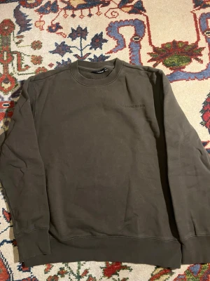 Mörkgrön sweatshirt från J.Lindeberg - Säljer en stilren mörkgrön sweatshirt från J.Lindeberg med diskret broderad logga på bröstet. Tröjan har rund halsringning, långa ärmar och är gjord i mjuk bomull. Perfekt för dig som gillar minimalistisk design.