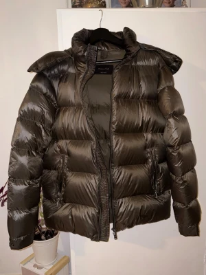 Dunjacka från Massimo Dutti - Säljer denna jacka från Massimo Dutti i storlek L.✅ Jackan har en avtagbar huva samt två dragkedjefickor på utsidan och en på insidan. Använt några gånger men mestadels hängt i garderoben. Den är storlek L men passar mig som är 178cm. Modellen är förövrigt utgånget ur sortimentet.
