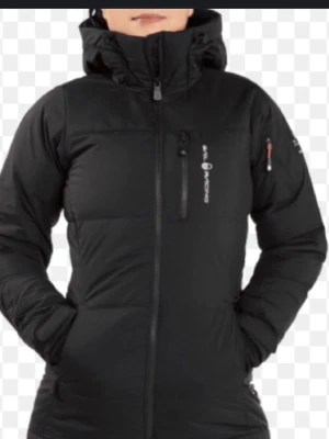 Svart dunjacka från sail racing - Säljer en svart dunjacka från  sail Racing med huva och dragkedja framtill. Jackan har en smal passform, långa ärmar och praktiska fickor. Perfekt för kalla dagar och riktigt snygg 