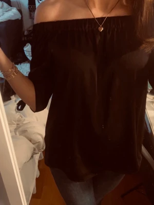 Svart offshoulder topp från H&M - Svart offshoulder topp från H&M i storlek 36. Toppen har trekvartsärmar med knyt vid ärmsluten.