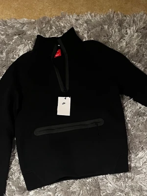 Svart half zip tröja från Nike - Säljer en svart tröja från Nike med half zip och hög krage. Perfekt för dig som gillar sportig och clean stil. Helt ny aldrig använt. nypris 1400