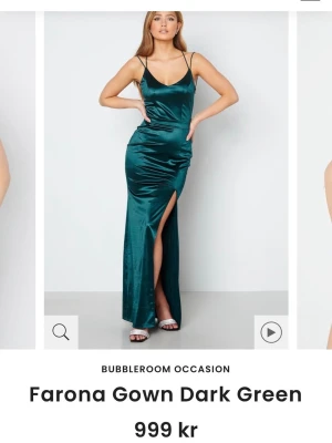 Mörkgrön långklänning från Bubbleroom - Supersnygg mörkgrön långklänning i satin från Bubbleroom med smala axelband, v-ringning och hög slits framtill. Klänningen har spetsdetaljer i ryggen och en figurnära passform som ger en elegant siluett. Perfekt för speciella tillfällen! Jag är 173 cm. Inga defekter.
