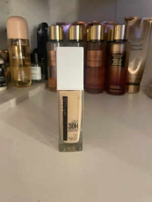 Maybelline 30H Foundation 112 - Maybelline Super Stay Active Wear Foundation i nyansen 112 Natural Ivory. Kommer i en rektangulär glasflaska med vit plastkork. Ger ett naturligt resultat och håller upp till 30 timmar. Perfekt för dig som vill ha en lätt men täckande bas. 