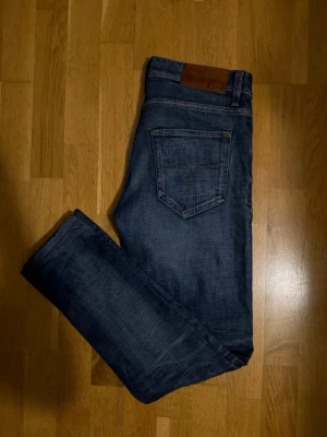 Tiger of Sweden washed jeans  - Säljer ett par klassiska blå jeans från Tiger of Sweden med raka ben och snygga kontrastsömmar. Riktigt snygg passform. Jeansen har fem fickor, bälteshällor och en läderpatch bak i midjan. Materialet är slitstarkt jeans.